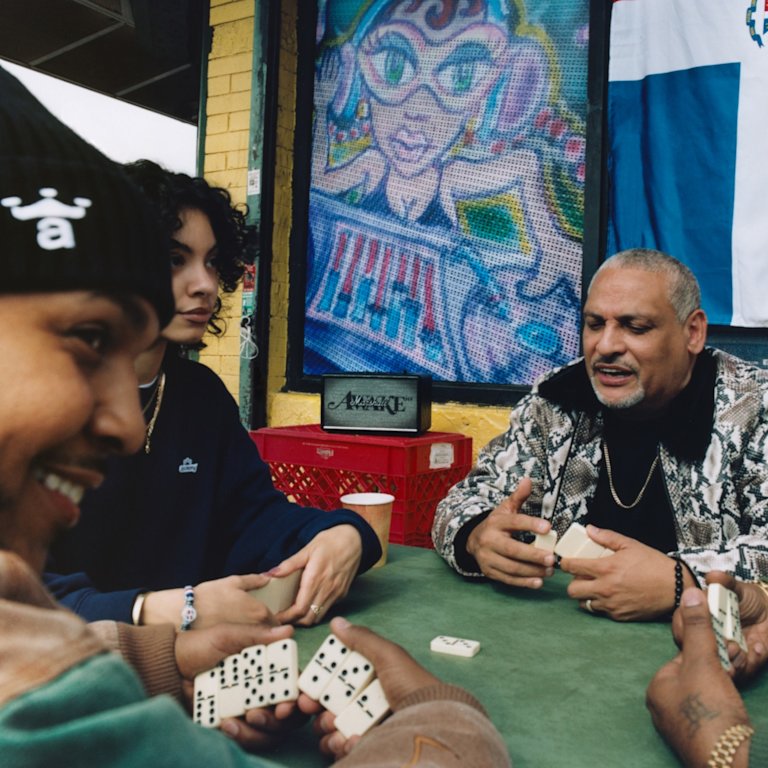 People playing dominoes at a table with Marshall Acton III Awake NY Edition speaker in the background.