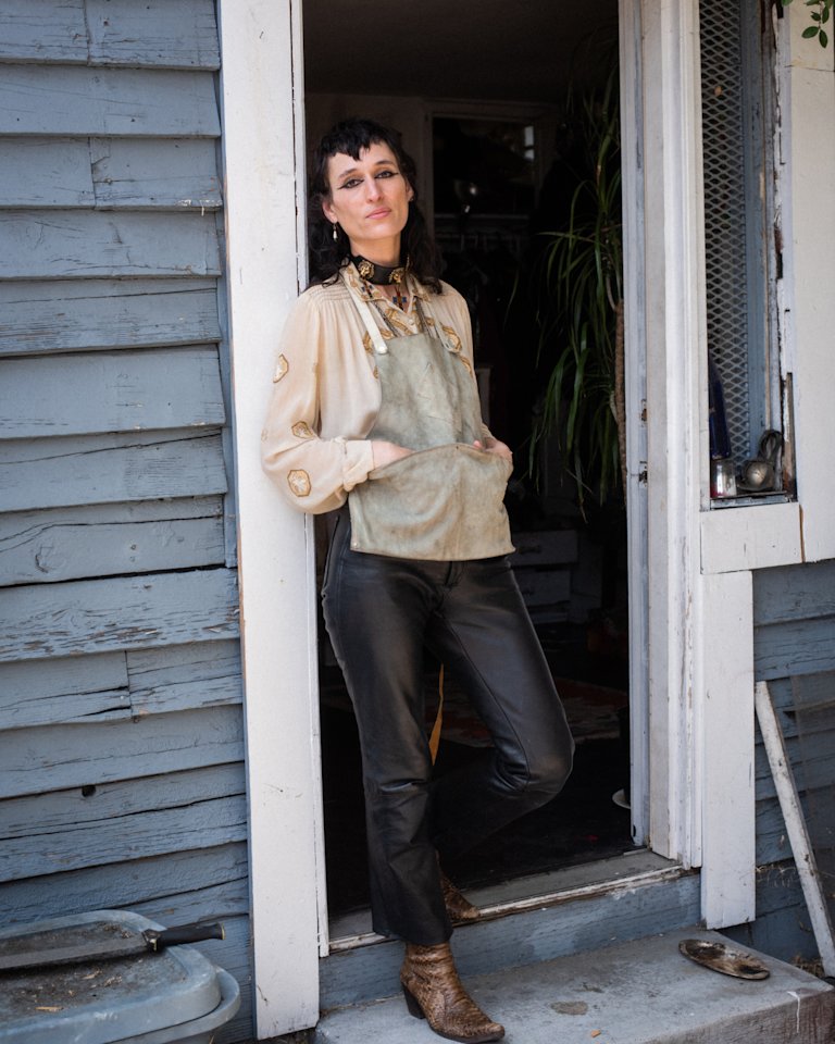Zumi Rosow is standing in front of a door.