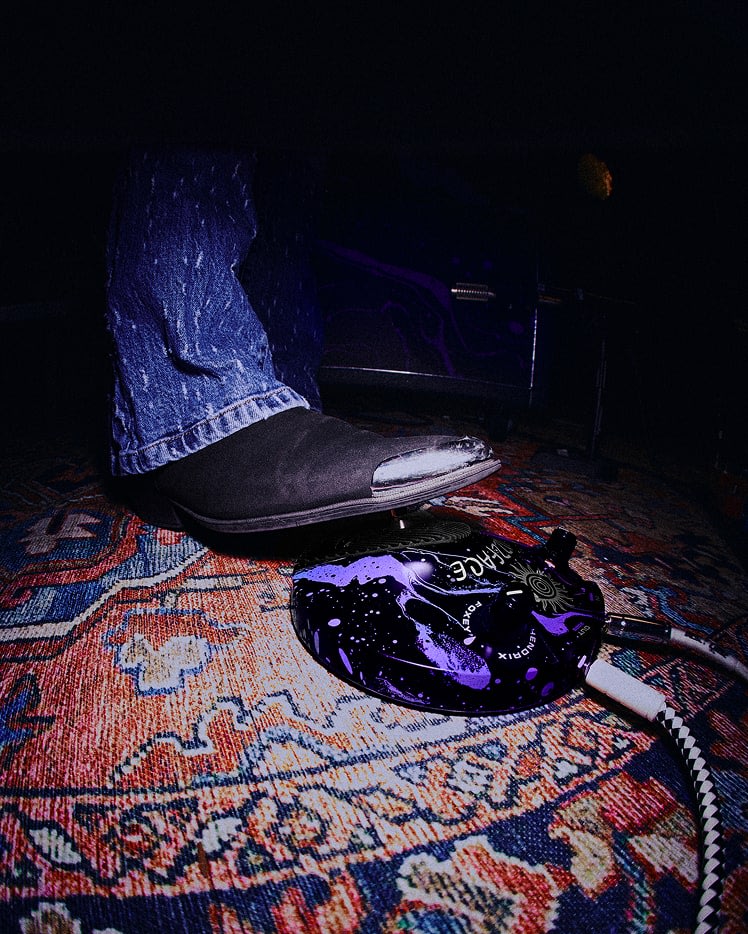 Une personne portant des chaussures noires et un jean bleu utilisant la distorsion JMH-1 Fuzz Face®.