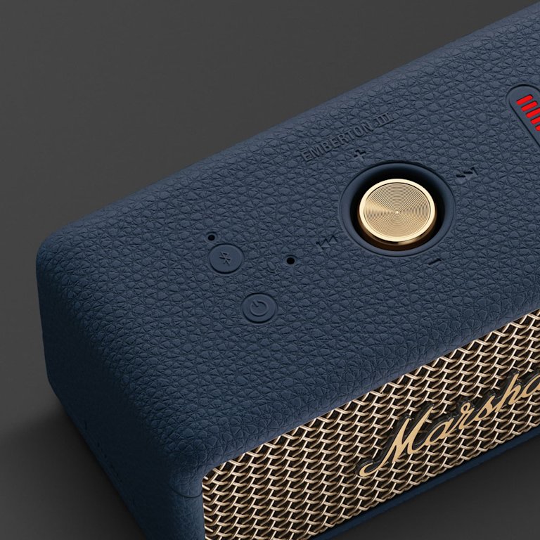 Close-up of the Marshall Emberton III Midnight Blue portable speaker, highlighting the power button, Bluetooth button, control knob, and a section of the iconic Marshall grille.