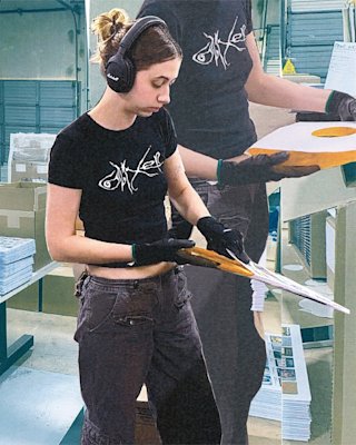 A person is working, placing vinyl records into their covers