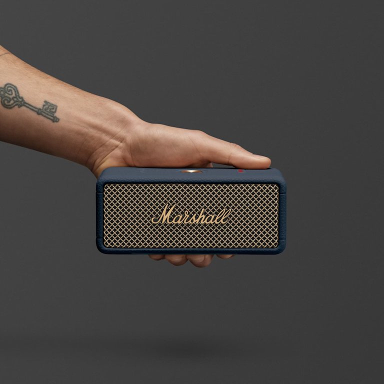 Marshall Emberton III Midnight Blue portable speaker with its gold mesh front and logo, set against a plain dark background.