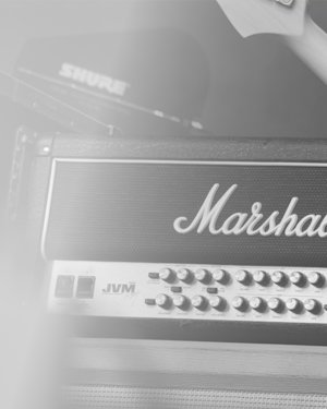 Image en noir et blanc d'un guitariste avec un amplificateur.
