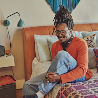 Seye sitting on a bed