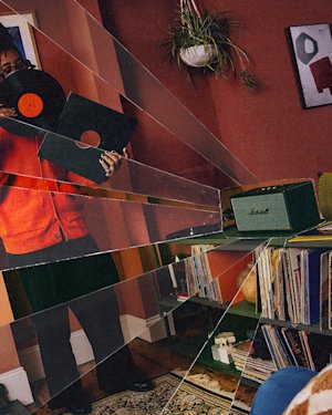 Seye holding a record whilst standing in front of the Marshall Stanmore IV Black and Brass