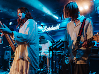 Two people are playing instruments live on stage