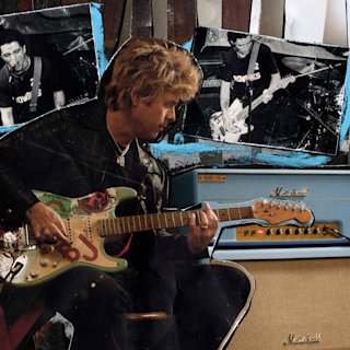 BJA playing guitar next to his amp