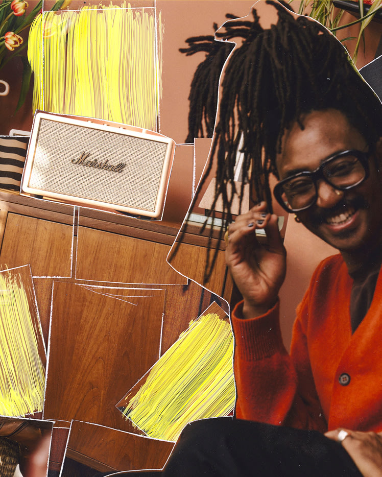 A person with orange sweater and glasses sitting in front of a Marshall Acton IV Cream speaker and wooden cabinet.