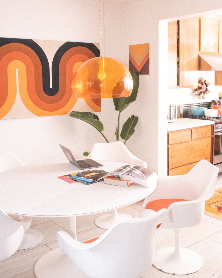 A kitchen with a white table and chairs.