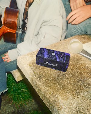 Emberton III Hendrix Edition portable speaker sits on a rough stone table.