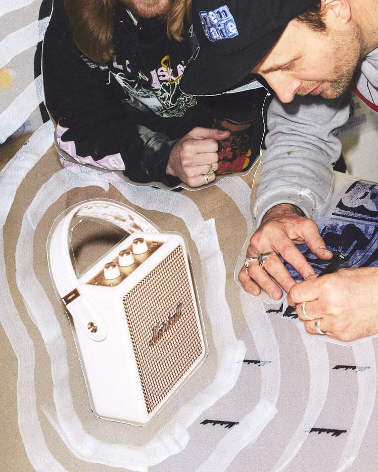 Two people sit at a table with Stockwell III Cream portable speaker and a patterned surface / A person carrying Stockwell III Cream.