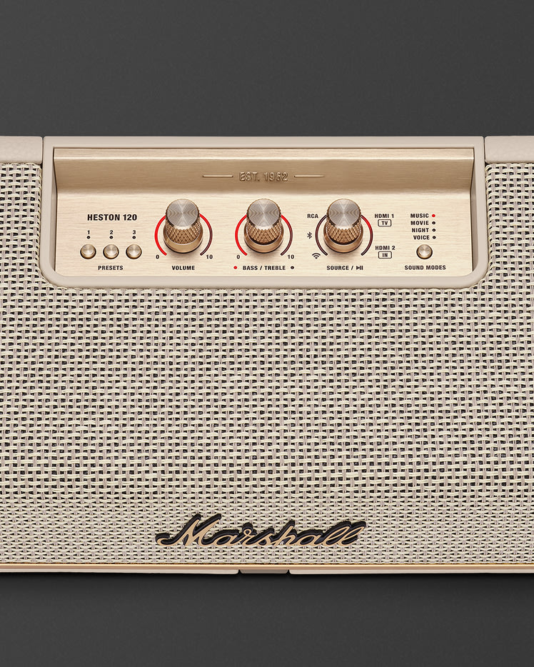 Panel de control superior de un altavoz Marshall Heston 120 Cream con mandos de color latón, botones de preselección y etiquetas de selección de fuente.