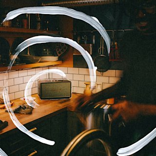 Stanmore IV Black on a kitchen counter with white painted swirl lines over the image and a blurred person in the foreground.