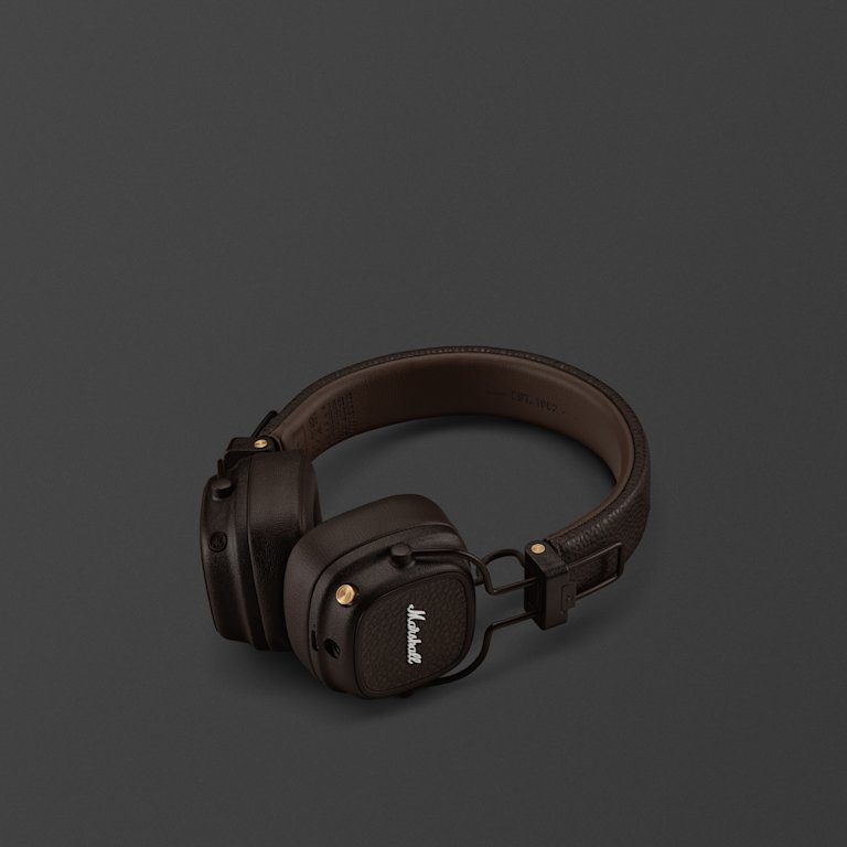 Marshall Major V Brown on-ear headphones with a coiled cable and brass accents on a dark gray surface.