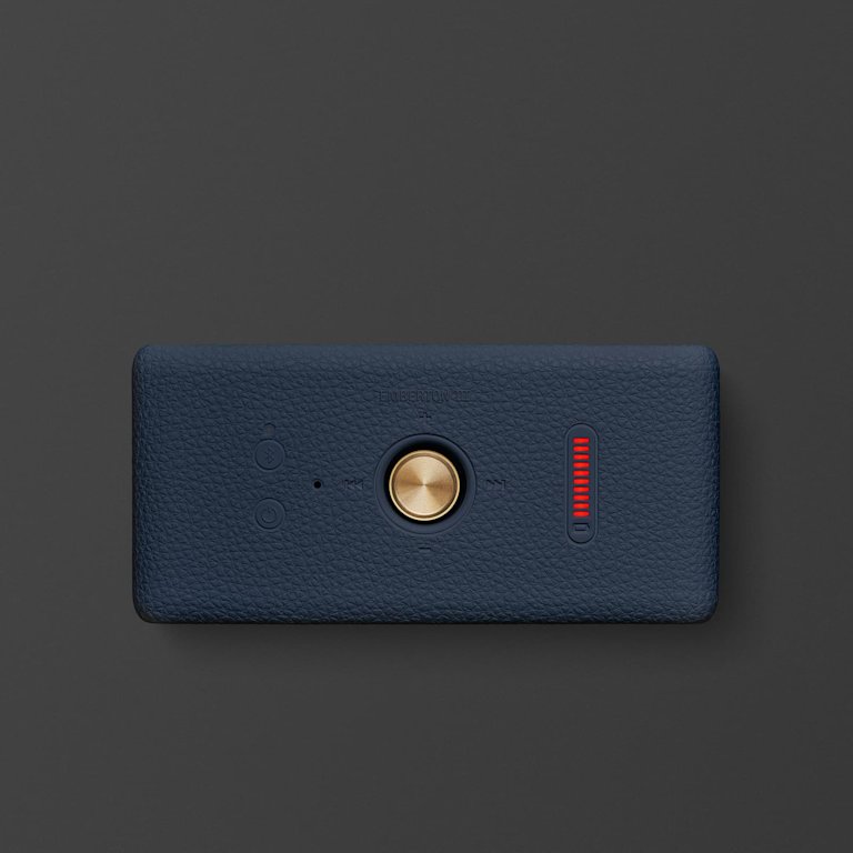 Marshall Emberton III Midnight Blue portable speaker with a textured dark blue surface, featuring a central gold button, two smaller buttons, and a red digital display on a black background.