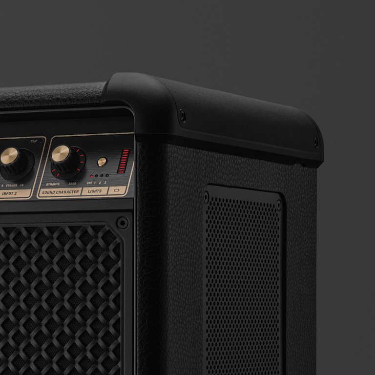 Close-up of the Marshall Bromley 750 with control knobs, textured grille, side handle, and mesh panel—evoking a party speaker’s power.