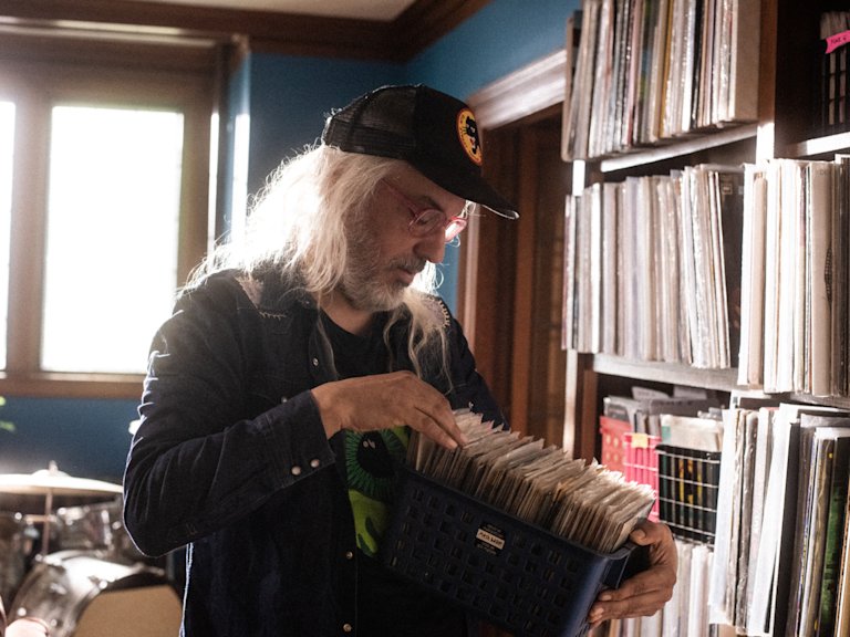 J Mascis sosteniendo una caja de singles de vinilo.