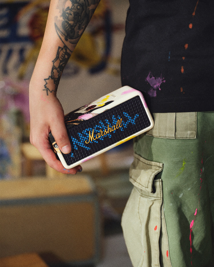 A person holds a Marshall Emberton III Lunar New Year Edition 2026 portable speaker decorated with colorful paint.