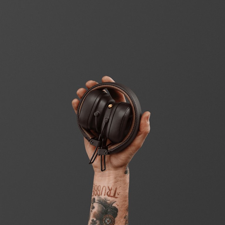 Hand holding a Marshall Major IV Brown over-ear headphone