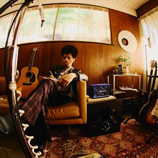 Acton III Hendrix Edition placed in an interior with sofa and guitars.