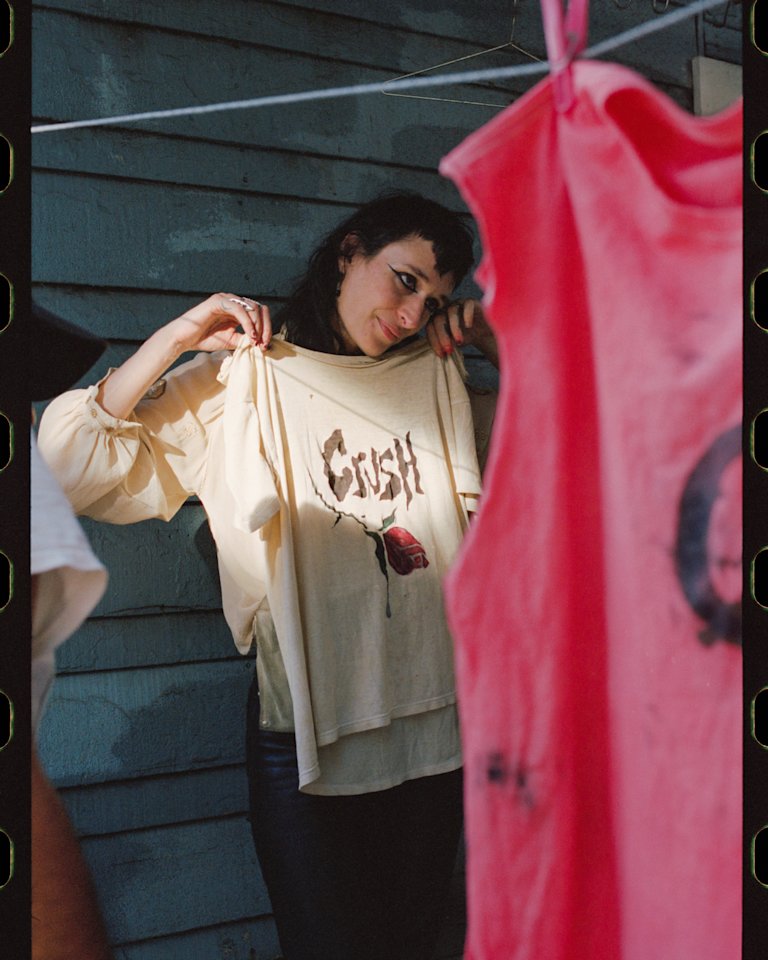 Zumi Rosow looking at a shirt hanging on a line.