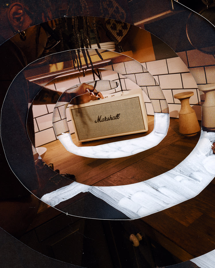A person adjusts Marshall Stanmore IV Cream speaker placed on a kitchen counter.