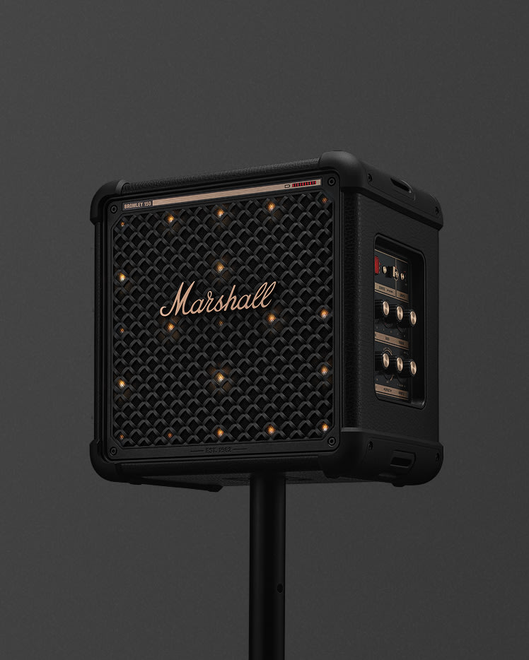 Bromley 150 Black and Brass on a black stand against a dark gray background, showing its front grille with the Marshall logo and side control panel.