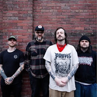 Cancer Bats in front of a brick wall