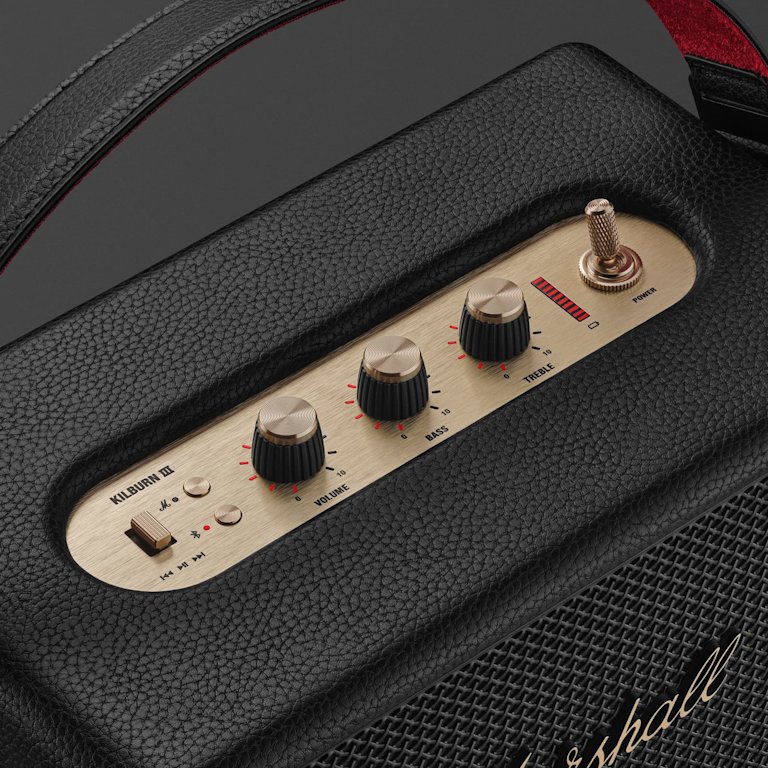 Close-up of the Marshall Kilburn III Black and Brass portable speaker control panel, displaying volume, bass, treble knobs, a power switch, and an input switch labeled Bluetooth and Aux.