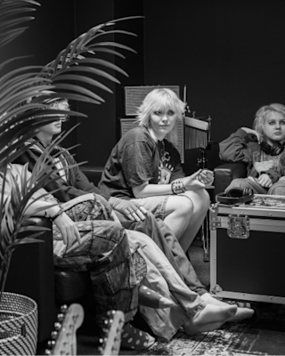 A group of people gathered on couches around the speakers
