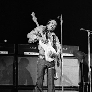 Jimi Hendrix playing his guitar in the Marshall Amplifiers in a Black and White photo