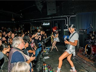 Nova Twins playing live on stage in a small venue