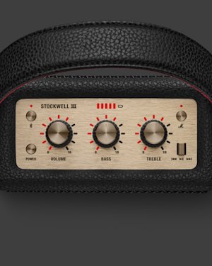 Close-up of a Stockwell III speaker control panel with dials for volume, bass, and treble, power and Bluetooth buttons, and playback controls, set in a black textured casing.