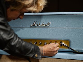 Billie Joe Armstrong adjusting the controls on a Marshall 1959 BJA Artist Signature.
