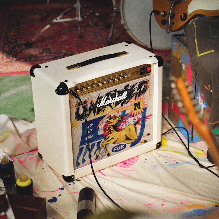 Marshall Studio 900 Combo Lunar New Year Edition 2026 is placed on a paint-splattered cloth surrounded by paint cans and a guitar.
