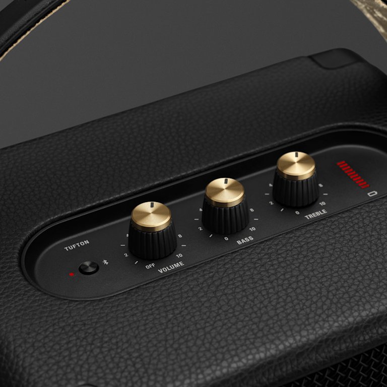 A close up look on the golden knobs of the Marshall Tufton black and brass speaker.