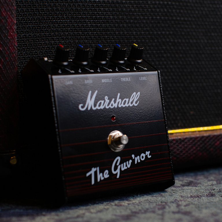A Guv'nor Vintage Reissue Pedal standing against the wall.