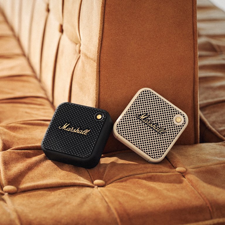 Willen Black and Brass wireless speaker on a brown couch.