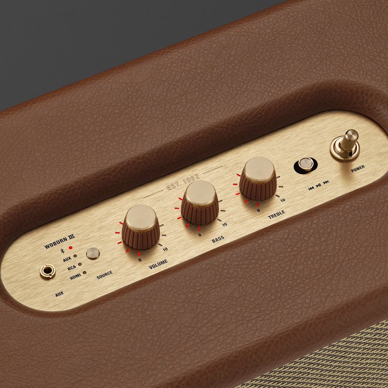 A close-up of the Marshall Woburn III home speaker control panel showing three knobs labeled volume, bass, and treble.