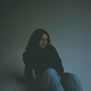 Mia sitting on the floor with a white background