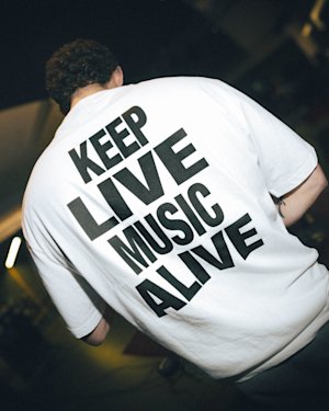 A person wearing the KLMA Tshirt in white