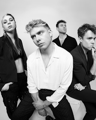 The band Daytime TV posing in front of a camera