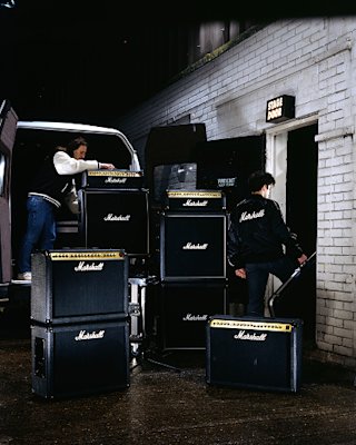 Marshall amps stacked high as people in Marshall merch walk by