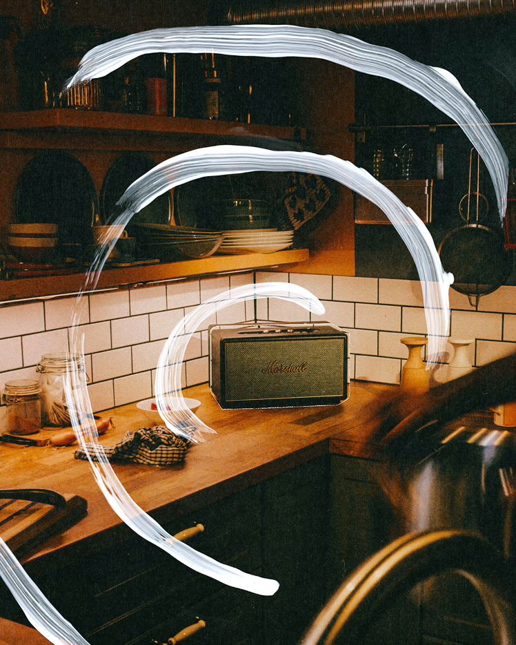 A kitchen counter with dishes, jars, and Marshall Stanmore IV Black speaker.