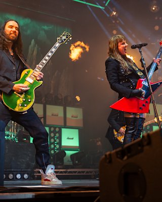 A band performing live on stage with Marshall amps in the background