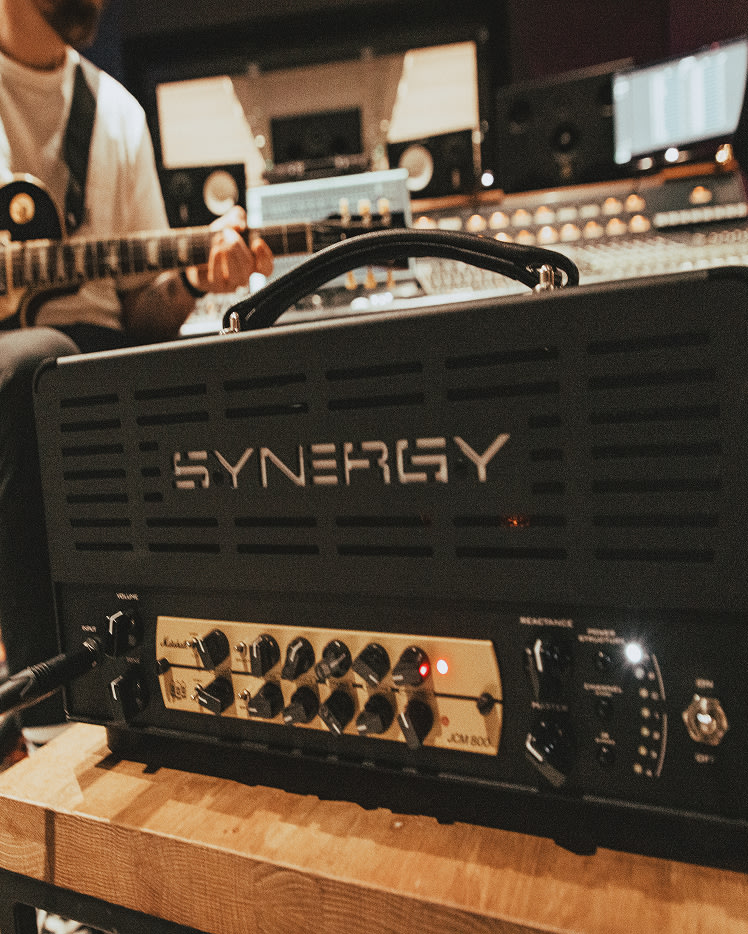 A close-up of a Marshall JCM800 Synergy Preamp Module on a wooden table in a recording studio.