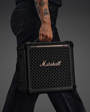 Person with tattoos carries Bromley 150 by its handle against a plain background.