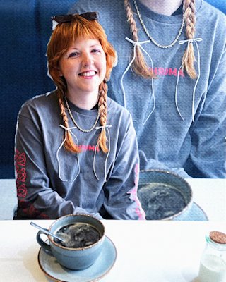 A person is with orange hair having tea