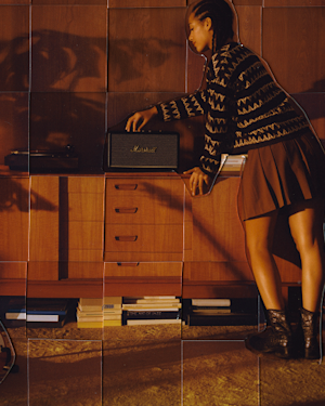 A person is adjusting the volume on a Woburn speaker