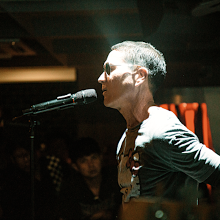 A person singing into a microphone with intense lightning)